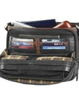Inside view of leather bag with plaid lining showing lots of storage space and card organizer slots.