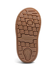 Brown outsole of children's shoe with sensory response stamped in middle and geometric designed tread.