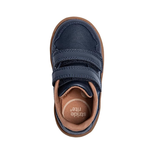 Top view of a navy blue children's shoe with two velcro straps, tan footbed and a brown outsole.