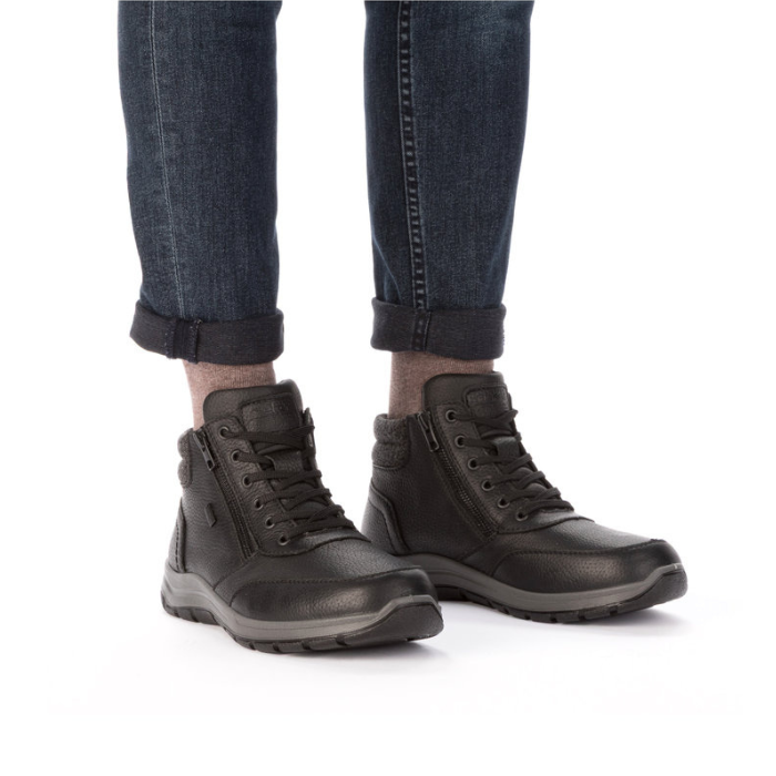 Black high top boots worn with dark blue jeans rolled at the ankle.