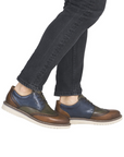 Brown and blue dress shoes worn with black jeans.