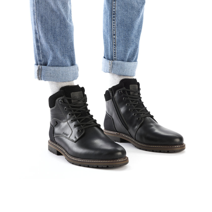 Black ankle boots with black laces worn with light blue jeans and white socks.