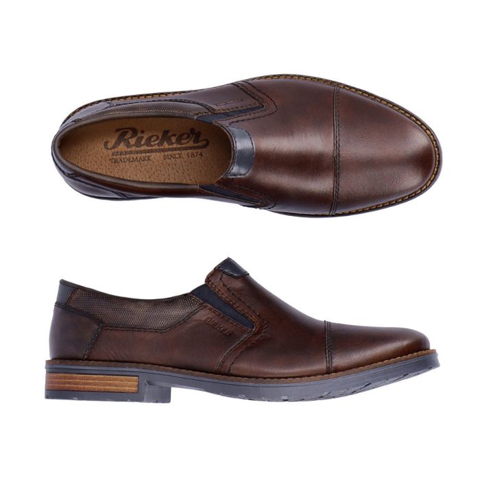 Brown leather slip-on dress shoe with toe cap and navy accents and navy outsole. Rieker logo on brown insole.