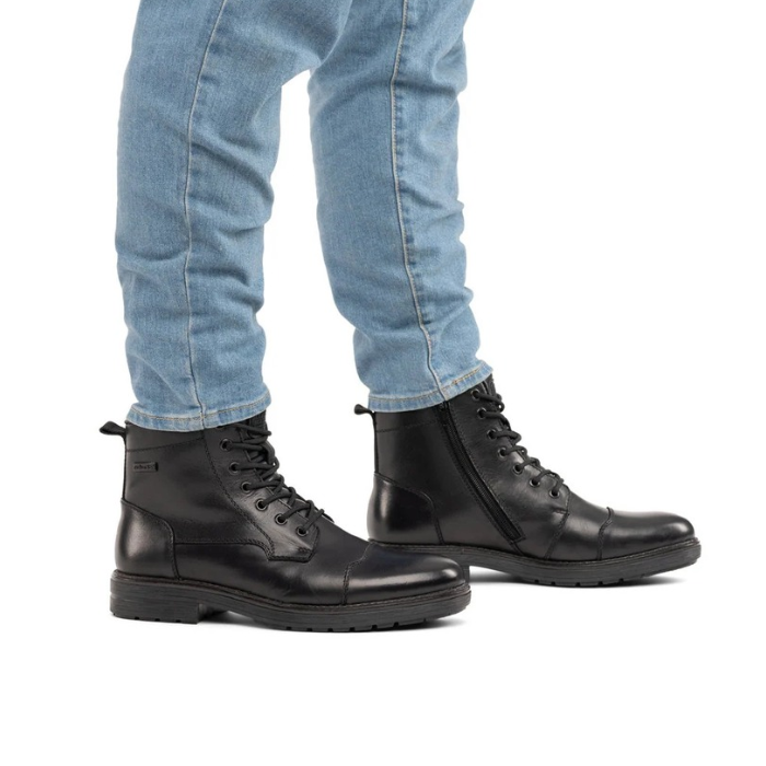 Man wearing blue jeans and black lace up ankle boots.