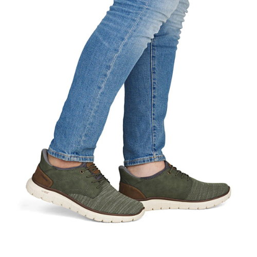 Green sneakers worn with blue jeans.