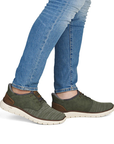 Green sneakers worn with blue jeans.