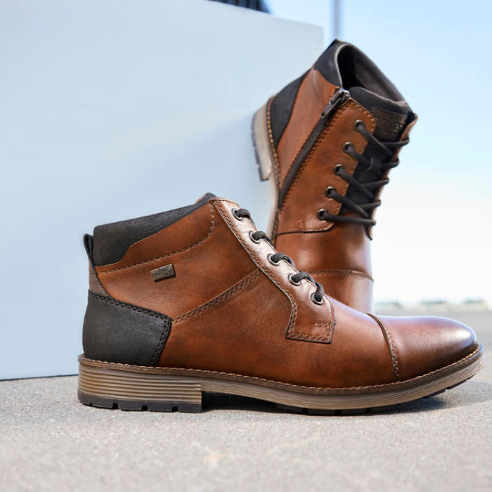 Brown dress boots on display in minimal style background.