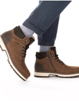 Brown winter ankle boots worn with grey pants.