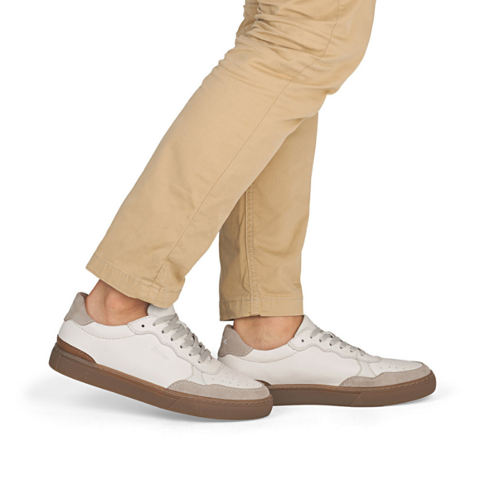 White sneakers with brown accents and outsoles worn with beige pants.