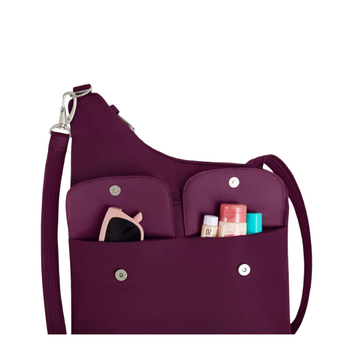 A deep purple one-shoulder crossbody bag with a shoulder strap and silver snap buttons, featuring two front utility pockets holding small accessories.