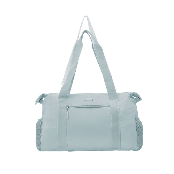 Light blue Travelon Pi Daily Carry Tote with minimalist design, front zipper pocket, and mesh side compartments for stylish, functional travel.
