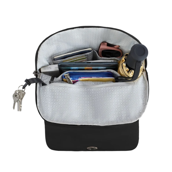 An open black zippered backpack with light grey interior lining filled with various travel accessories, including a pink watch, wallet, keys, and a rolled umbrella.