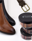 Brown and black leather boots with a belt and Volant James containers.