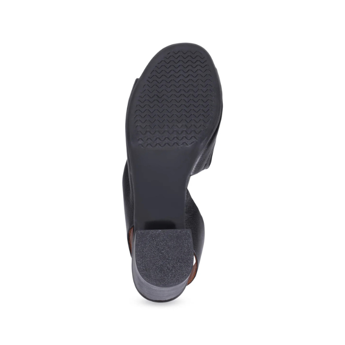 Black rubber outsole of block heel sandal with light wave tread pattern.