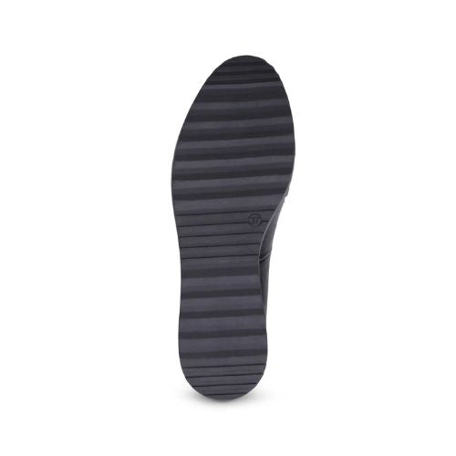 Light treaded black rubber outsole of a wedge heel loafer.