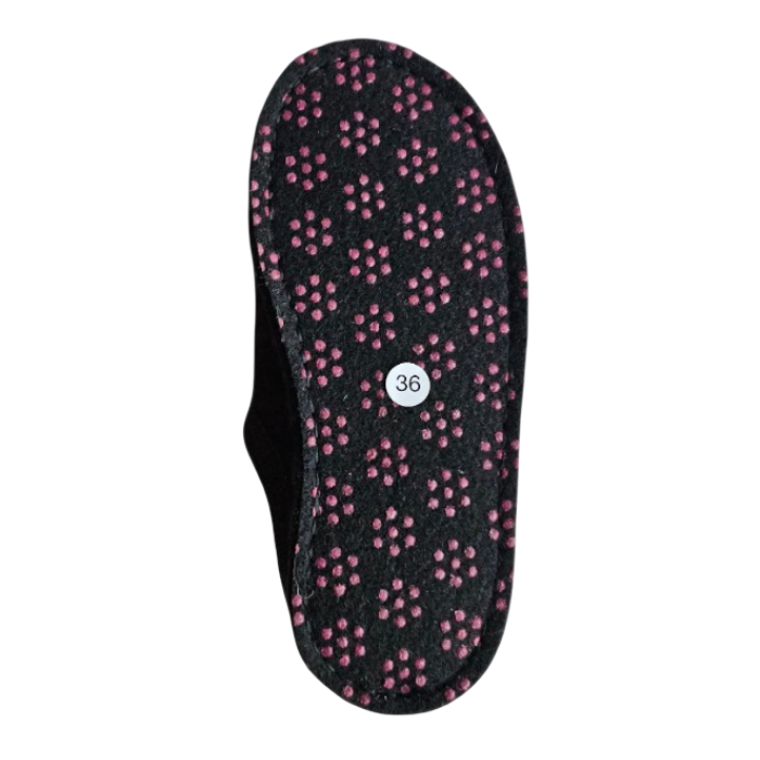 Outsole of a green slipper with repeating pattern of small red circular dots (traction dots).
