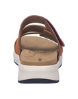 Back view of a sandal with colorful straps, tan footbed, white midsole and black outsole.