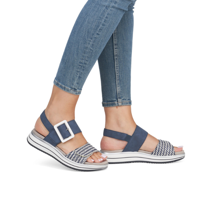 Navy and white backstrap sandal worn with blue jeans.