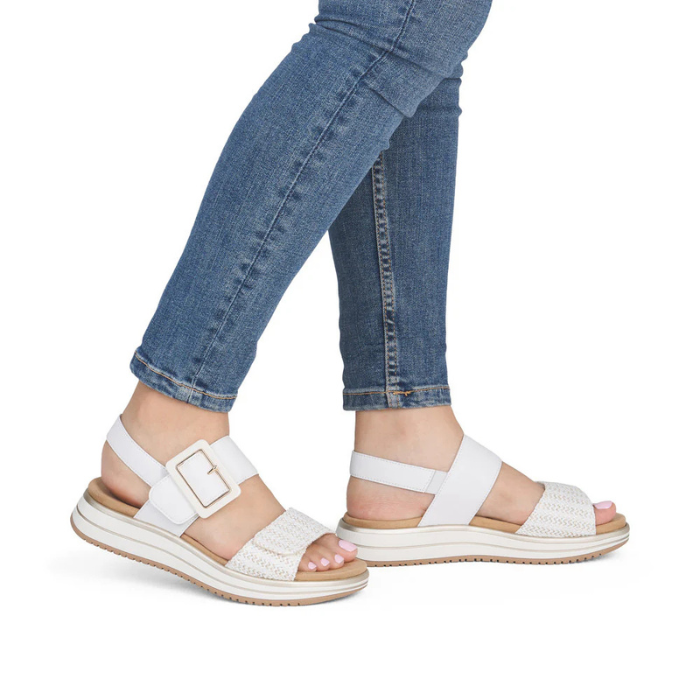 White and gold sandals worn with blue jeans.