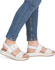 White and gold sandals worn with blue jeans.
