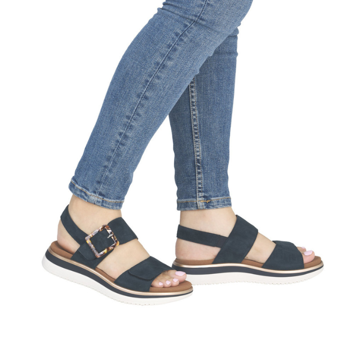 Navy backstrap sandals worn with blue jeans.