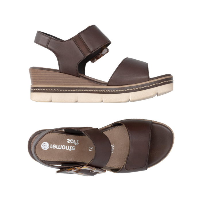 Pair of Dark Brown backstrap platform sandals with oversized decorative buckle, two Velcro straps, Remonte logo'd footbed, a faux wood grain wedge midsole and  an off-white outsole.