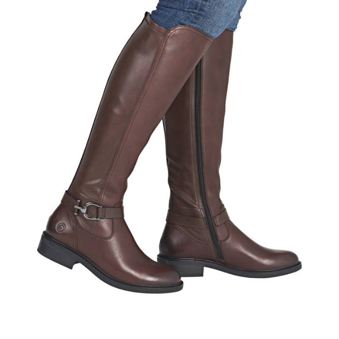 Brown knee-high boots with a buckle on ankle worn with blue jeans.
