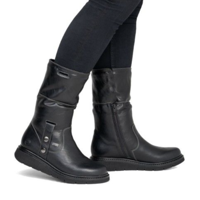 A pair of black leather mid-calf boots with side buckle straps worn with black  jeans.