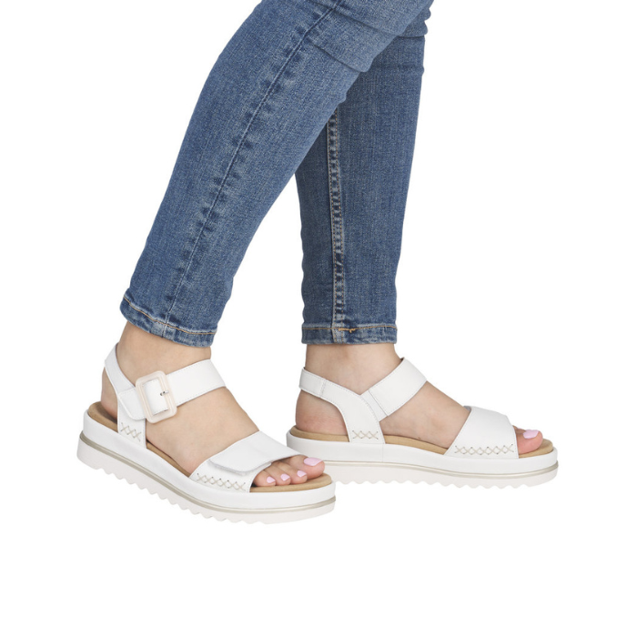 White backstrap sandals worn with blue jeans.