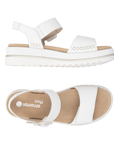 Pair of White backstrap sandals with beige buckle detail. accent "X" stitching, tan Remonte logo'd footbed and white outsole.