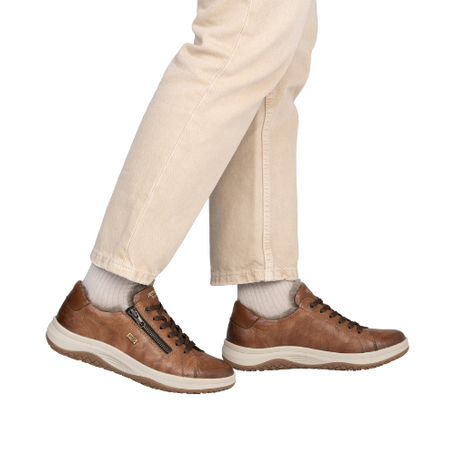Brown leather shoes worn with beige pants.