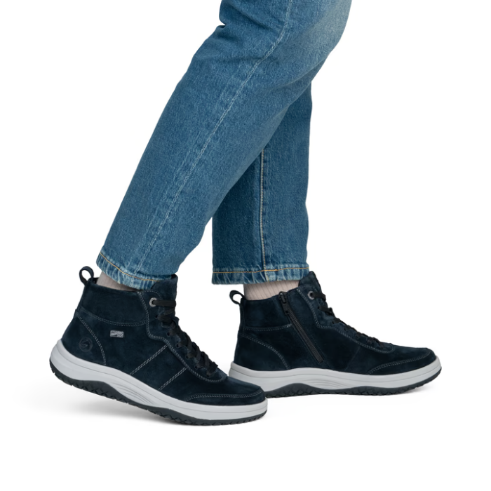 Navy blue sneaker boots worn with blue jeans.