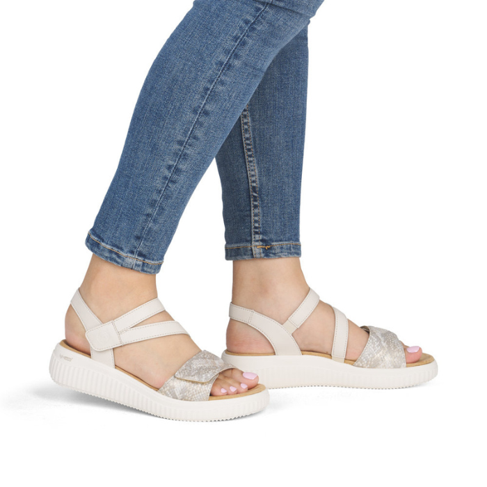 White backstrap sandals worn with blue jeans.