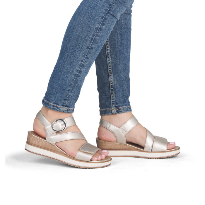 Gold strapy wedge sandals worn with jeans.