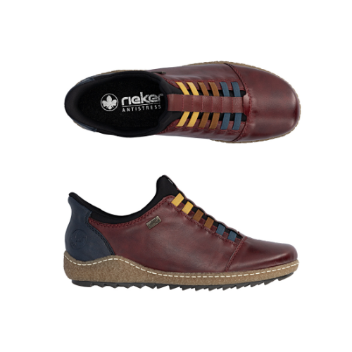 Pair of deep red slip-on shoes with a black heel tab,  colorful elastic laces in yellow, brown, and blue, black Rieker logo'd footbed, a  beige textured midsole and black treaded outsole.