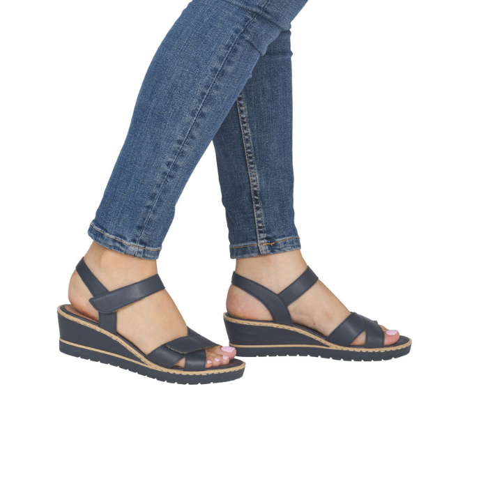 Navy wedge backstrap sandals worn with blue jeans.