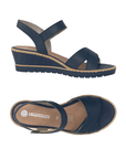 Pair of Navy blue backstrap wedge sandals with cross straps over toe, tan Remonte logo'd footbed and navy outsole.