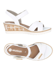 Pair of White backstrap sandals with gold bar details, tan Remonte logo'd footbed, white scratched faux cork midsole and white outsole.