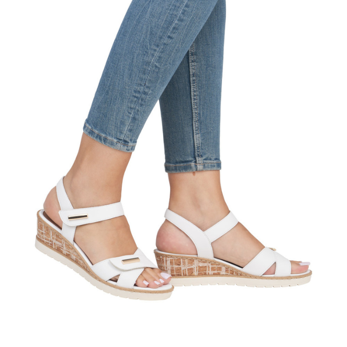 White sandals with faux cork midsole worn with blue jeans.