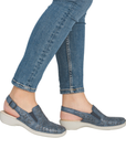 Blue sandals worn with rolled-up jeans.