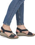 Navy wedge sandals with faux espadrille midsole worn with blue jeans.