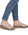 Beige slide sandals worn with blue jeans.