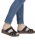 Navy sparkly slide sandals worn with blue jeans.