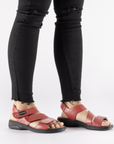 Model wearing red Backstrap Leather Sandals styled with jeans.