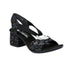 Slingback heel in black with shimmery metallics floral pattern, a silver circle medallion looping over straps, black Rieker logo'd footbed and a block heel. 