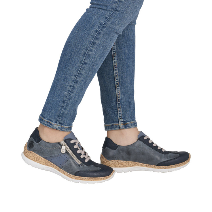 Blue sneakers with faux cork midsoles worn with blue jeans.