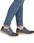 Blue sneakers with faux cork midsoles worn with blue jeans.