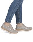 Beige with shimmery section sneakers with faux cork midsole worn with blue jeans.