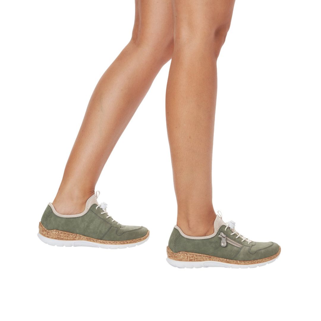 Model wearing Rieker N42G0 women's slip-on sneakers in green, showcasing stylish comfort and cushioned support for everyday use.