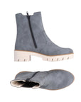 Blue Chelsea boot with platform lugged white outsole. Boot has black zipper closure.